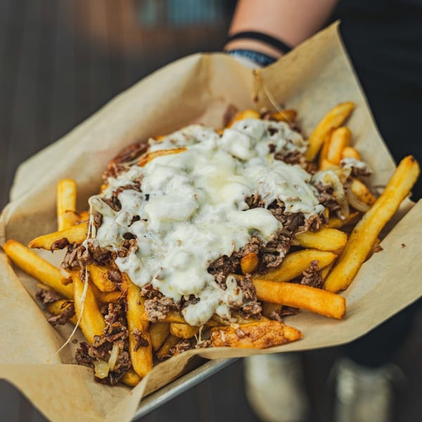 Inky's cheesesteak fries, golden fries topped with chopped steak, onions, and melted white cheese.